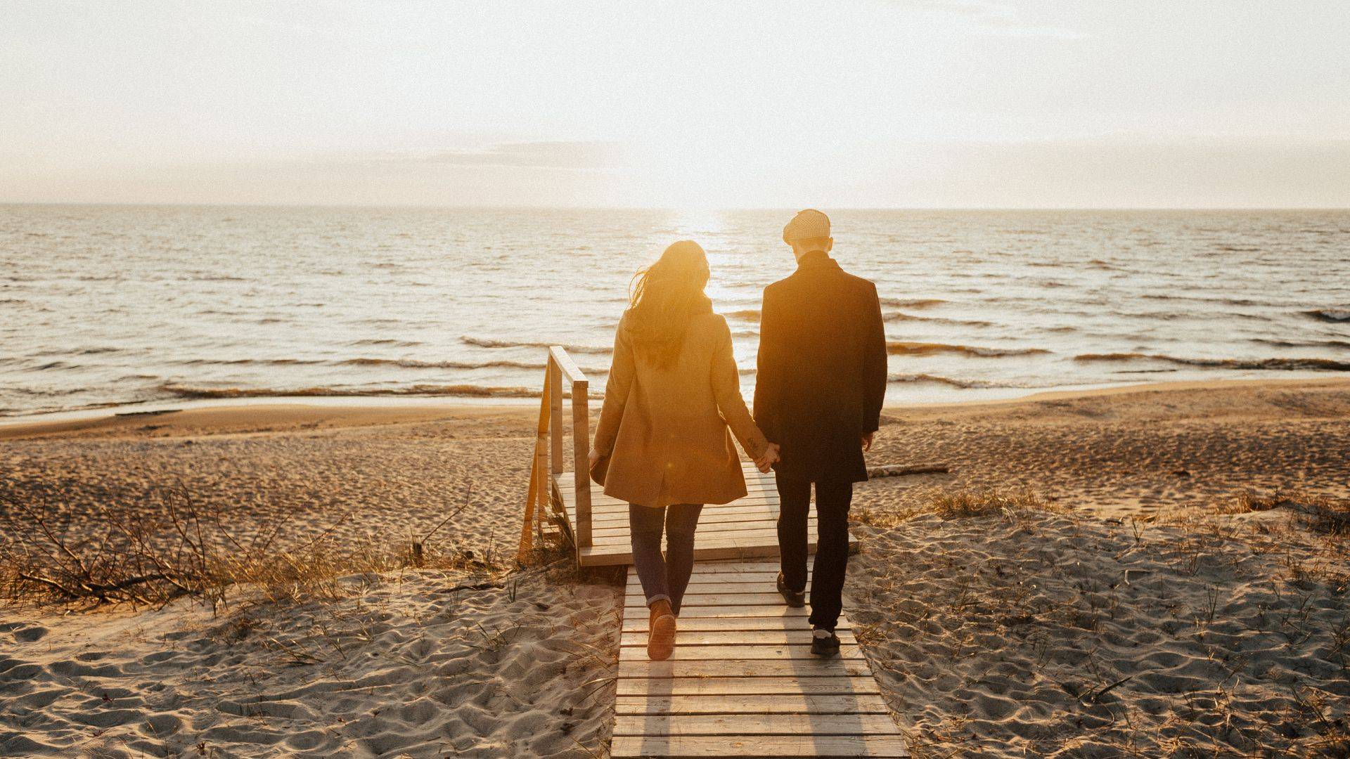 Website Photo of couple walking on beach 1920x1080